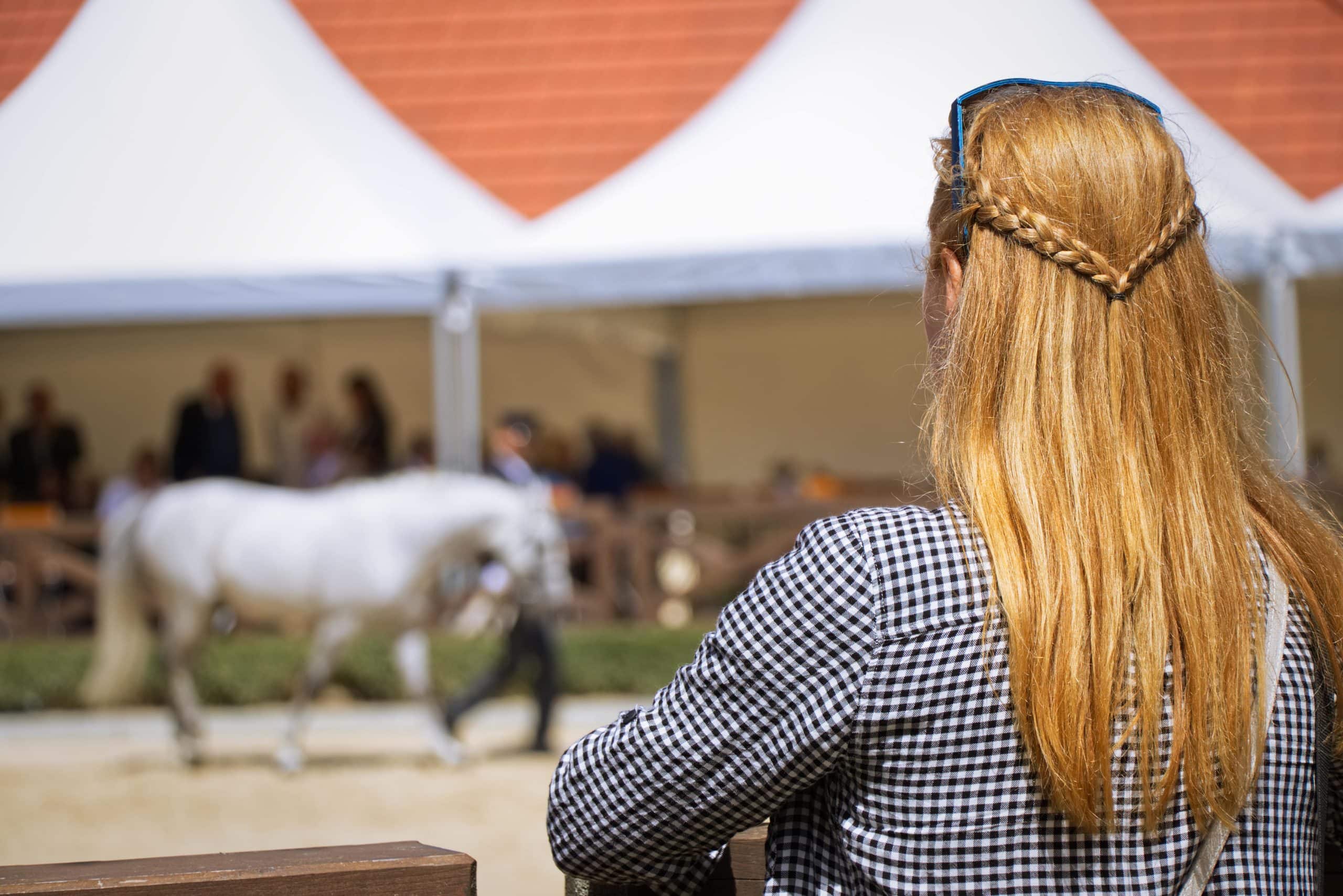 Femme qui regarder un cheval lors d'une vente aux enchères